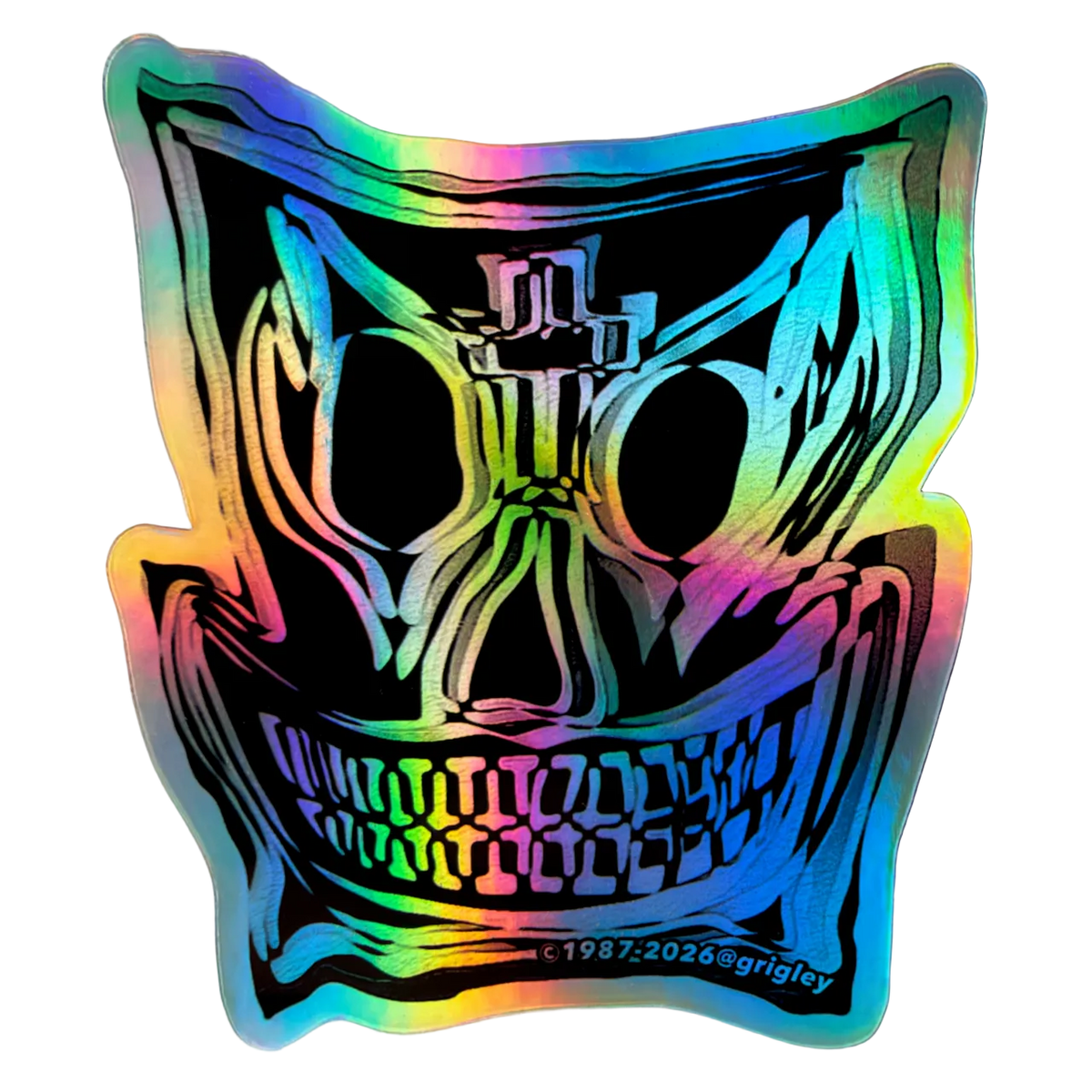 A die-cut sticker featuring a stylized skull graphic with a holographic rainbow sheen, shown on a light gray textured background.