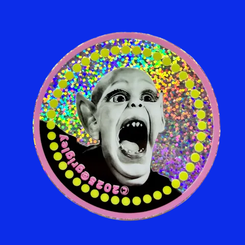 Circular sticker with a screaming Bat Boy face design on a colorful glittery polka dot background