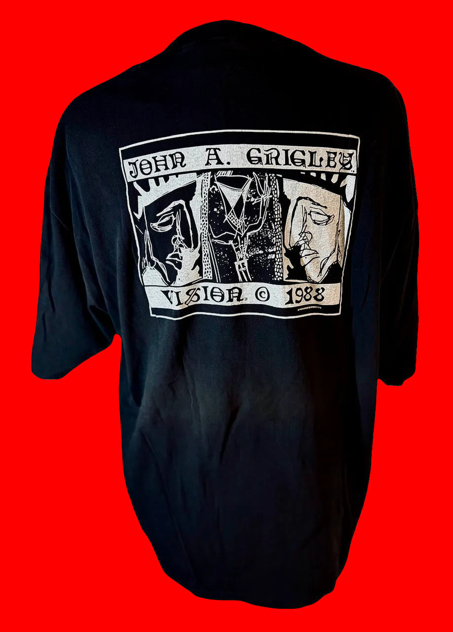 A black short-sleeve t-shirt shown from the back, featuring a large white graphic print with the text 'JOHN A. GRIGLEY' and 'VISION © 1988' surrounding three stylized faces.