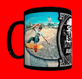 A black ceramic mug featuring a wrap-around graphic print of a skateboarder in a skatepark and a black-and-white decorative side panel with the text 'Go Skate America'.