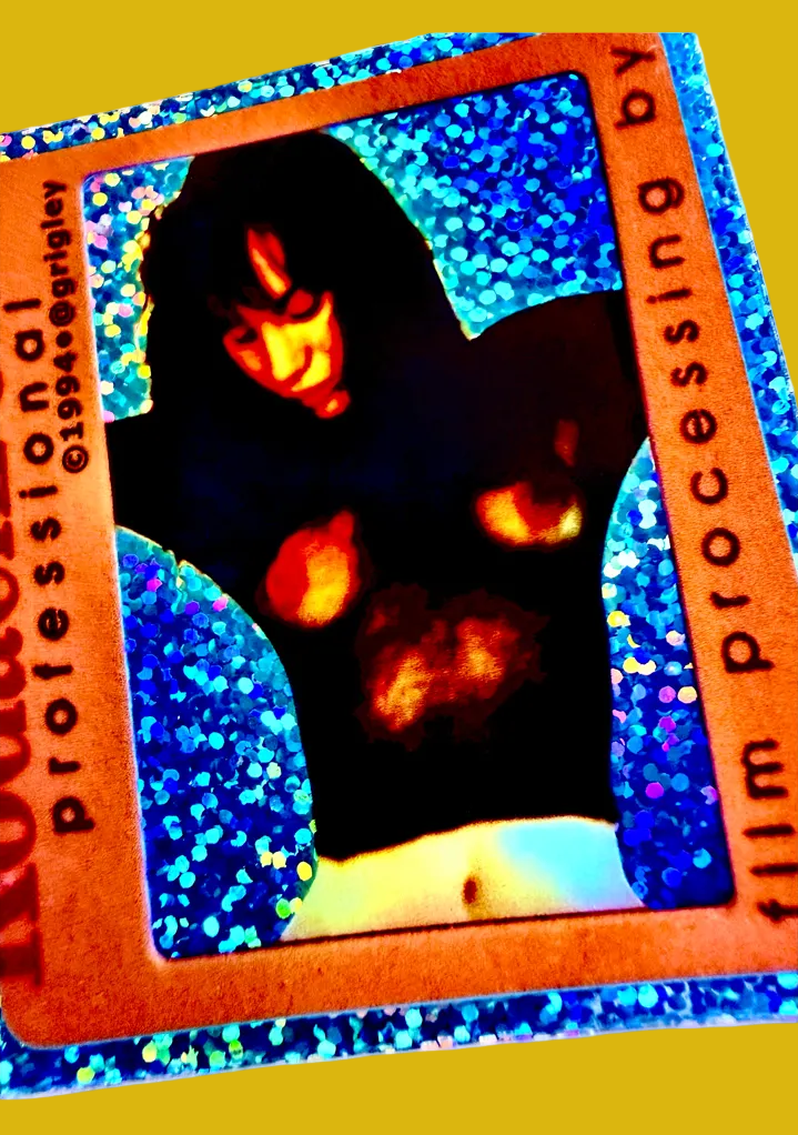 Holographic card with a person in a dark outfit against a blue glittery background