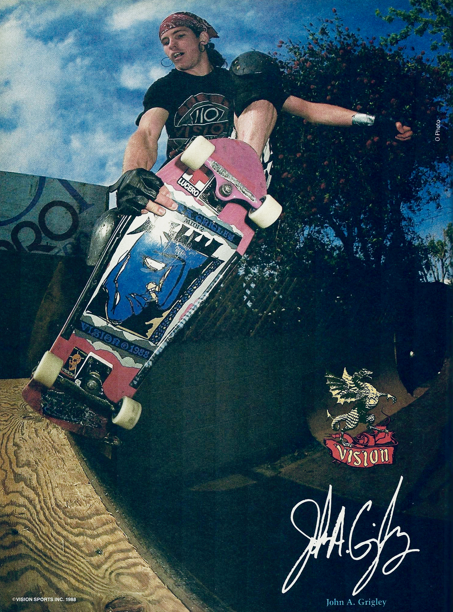 Grigley holding a skateboard with a visible signature, set against a scenic background.