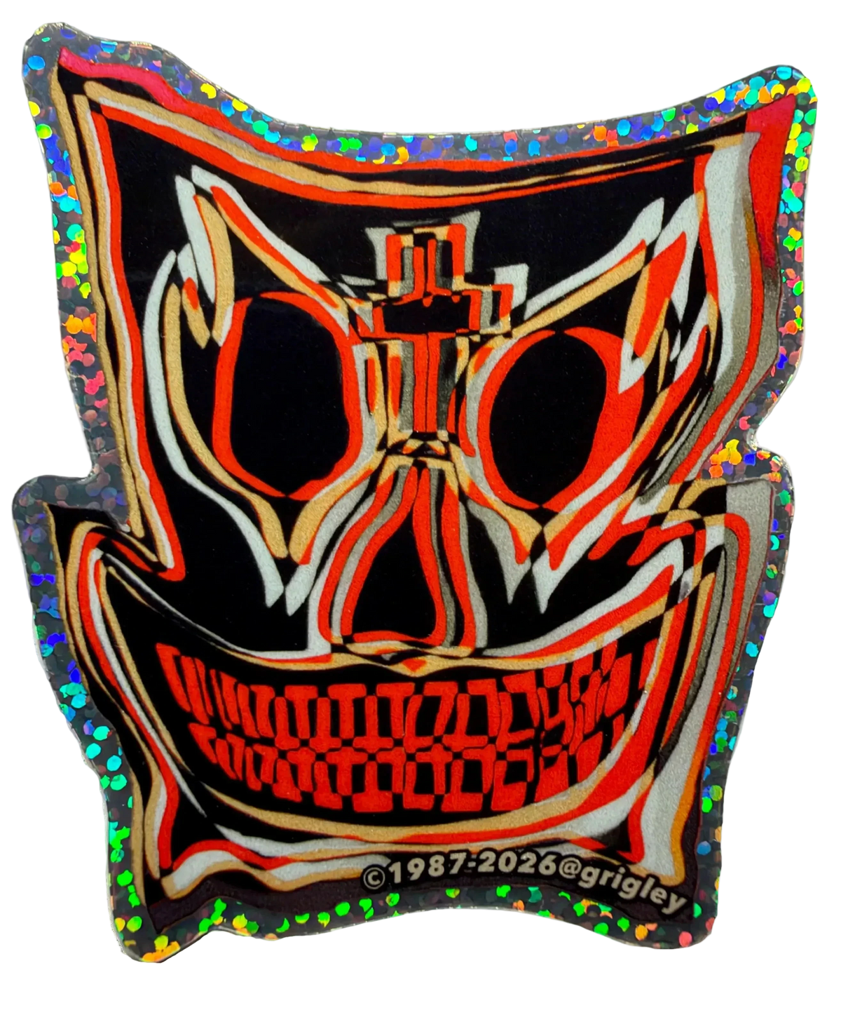 A mask-shaped 2026 new rendition of a 1987 John A. Grigley Pro Model Skateboard Decal with a black base and bold red, orange, beige, and white graphic lines, outlined in holographic glitter. The design includes a stylized face with large eye sockets, a cross motif above the nose, and a wide toothy grin.