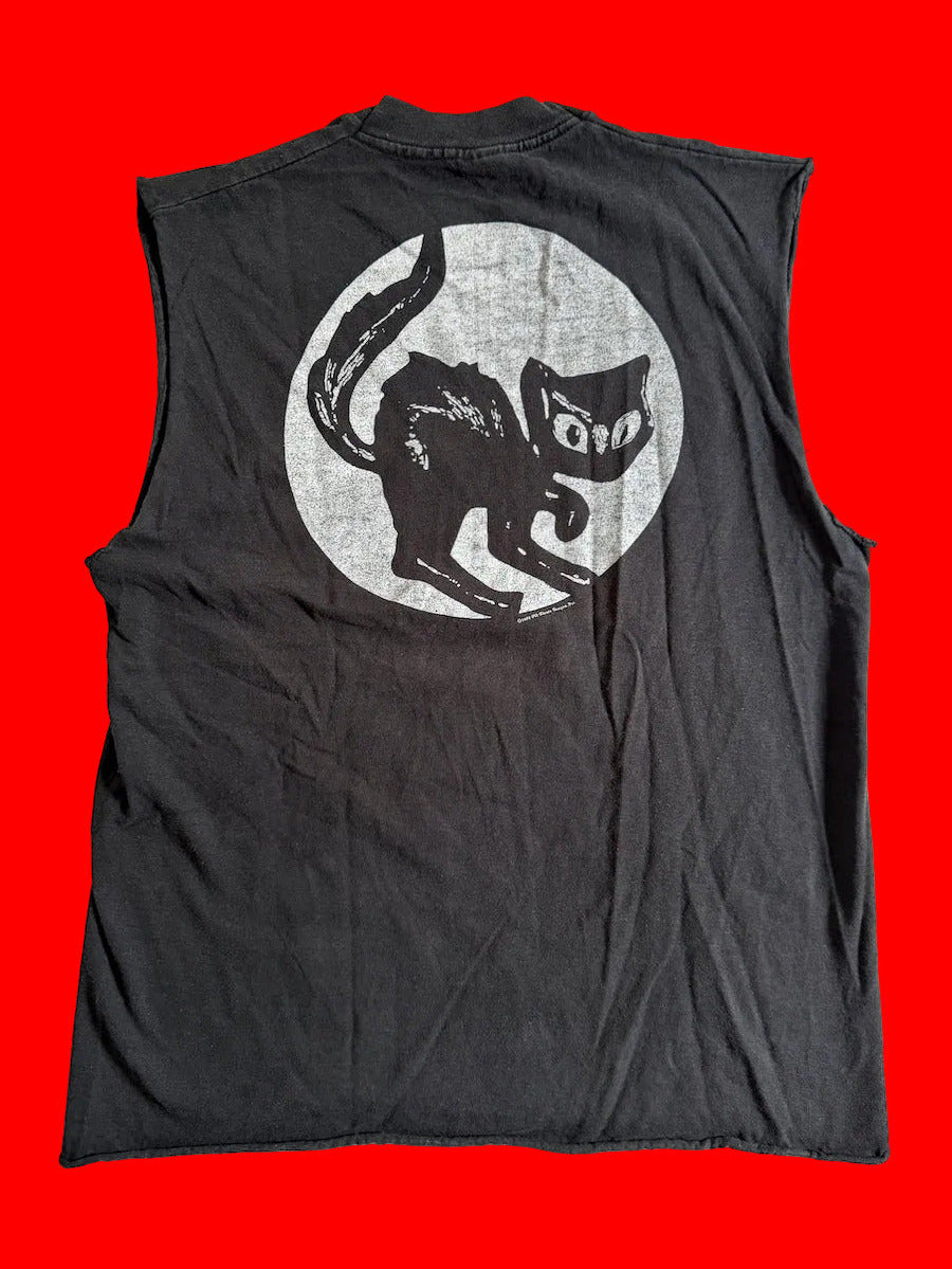 A black sleeveless tee shirt laid flat on a red background, featuring a large back graphic of a black Halloween cat silhouette inside a distressed white circle.