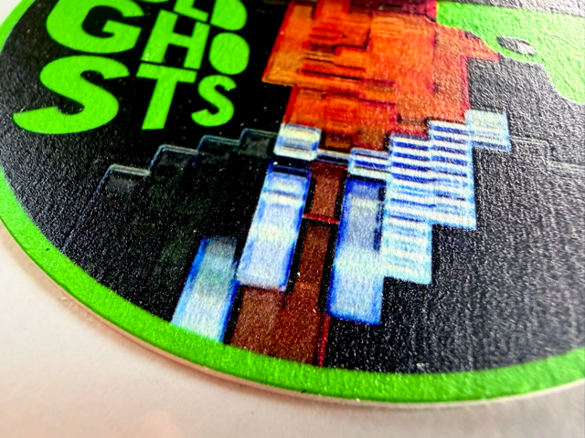 Pixelated character on a round object with 'GHOSTS' text