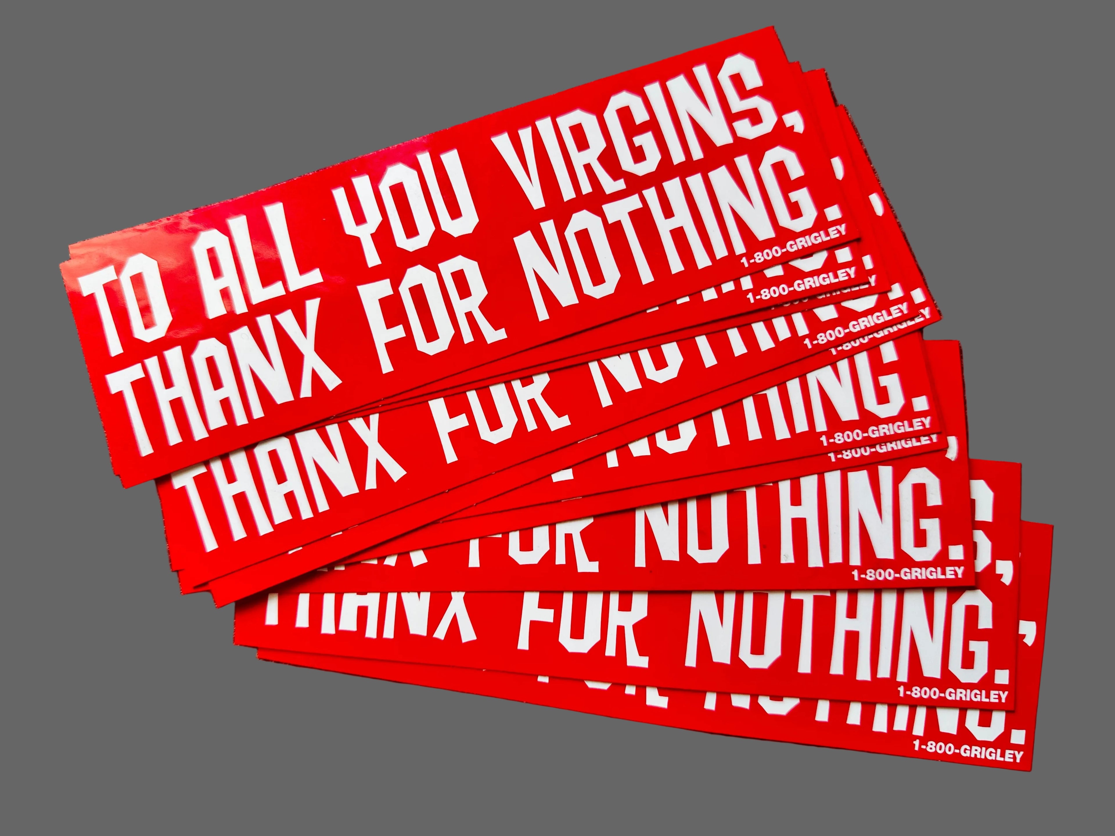 Stack of red stickers with white text on a textured surface